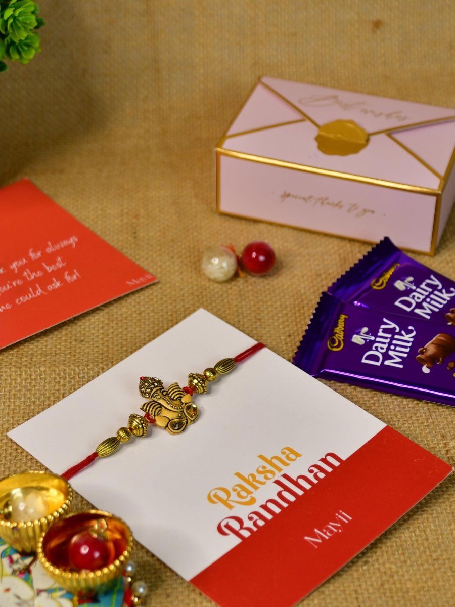 Sowpeace Exquisite Golden Ganesha Rakhi Pack of 1 with Roli Chawal Thali, Chocolates, and Greeting card combo for Raksha Bandhan and Gifting