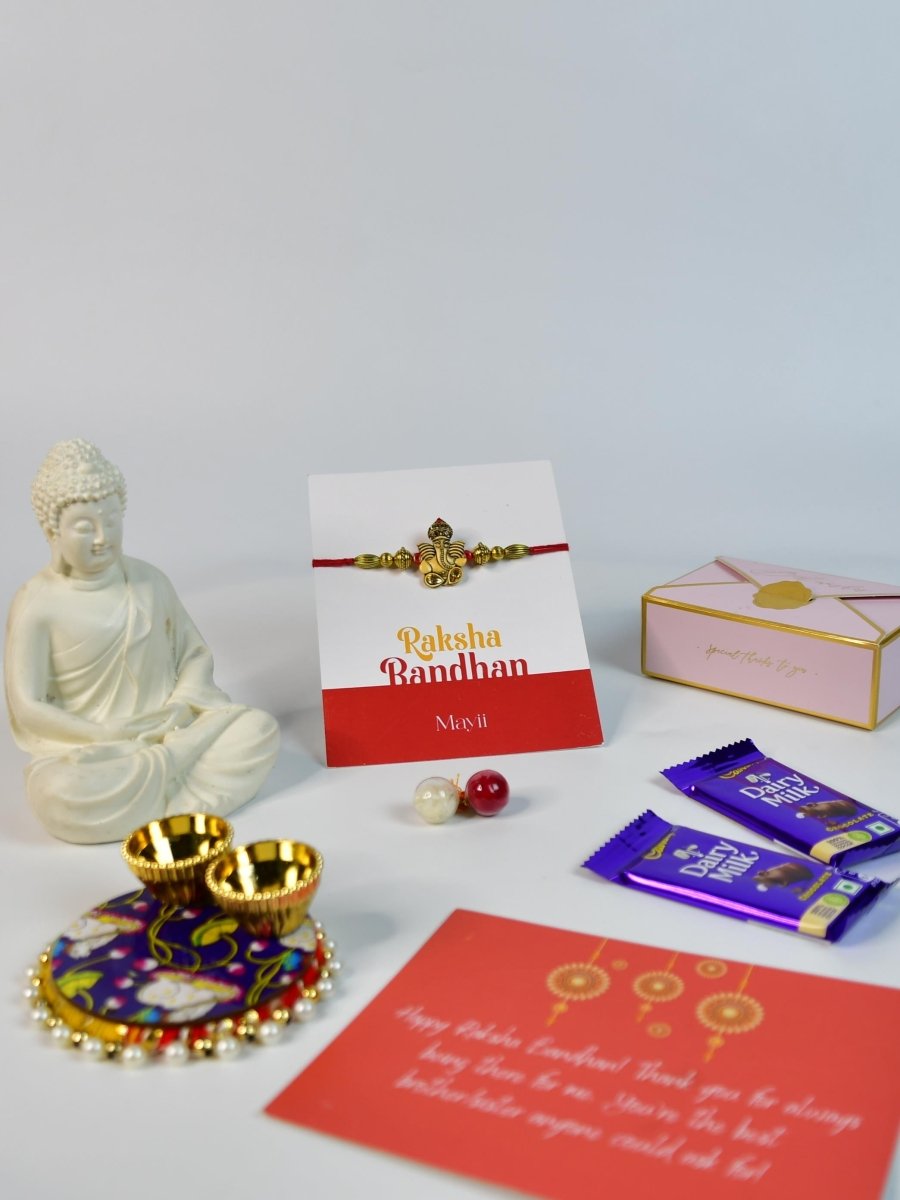 Sowpeace Exquisite Golden Ganesha Rakhi Pack of 1 with Roli Chawal Thali, Chocolates, Buddha and Greeting card combo for Raksha Bandhan and Gifting